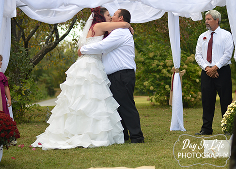 Fall wedding ceremony bride kisses her groom